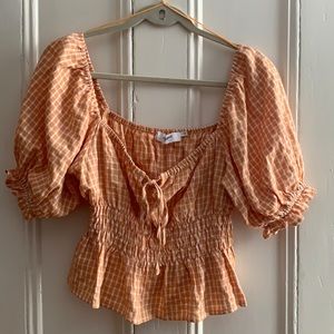 Orange and white crop top with balloon sleeves.